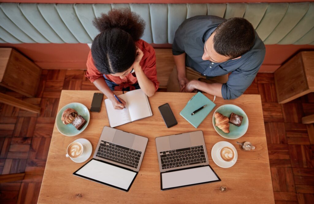 Working, coffee shop and laptops with mockup and business worker group planning a strategy. Table t