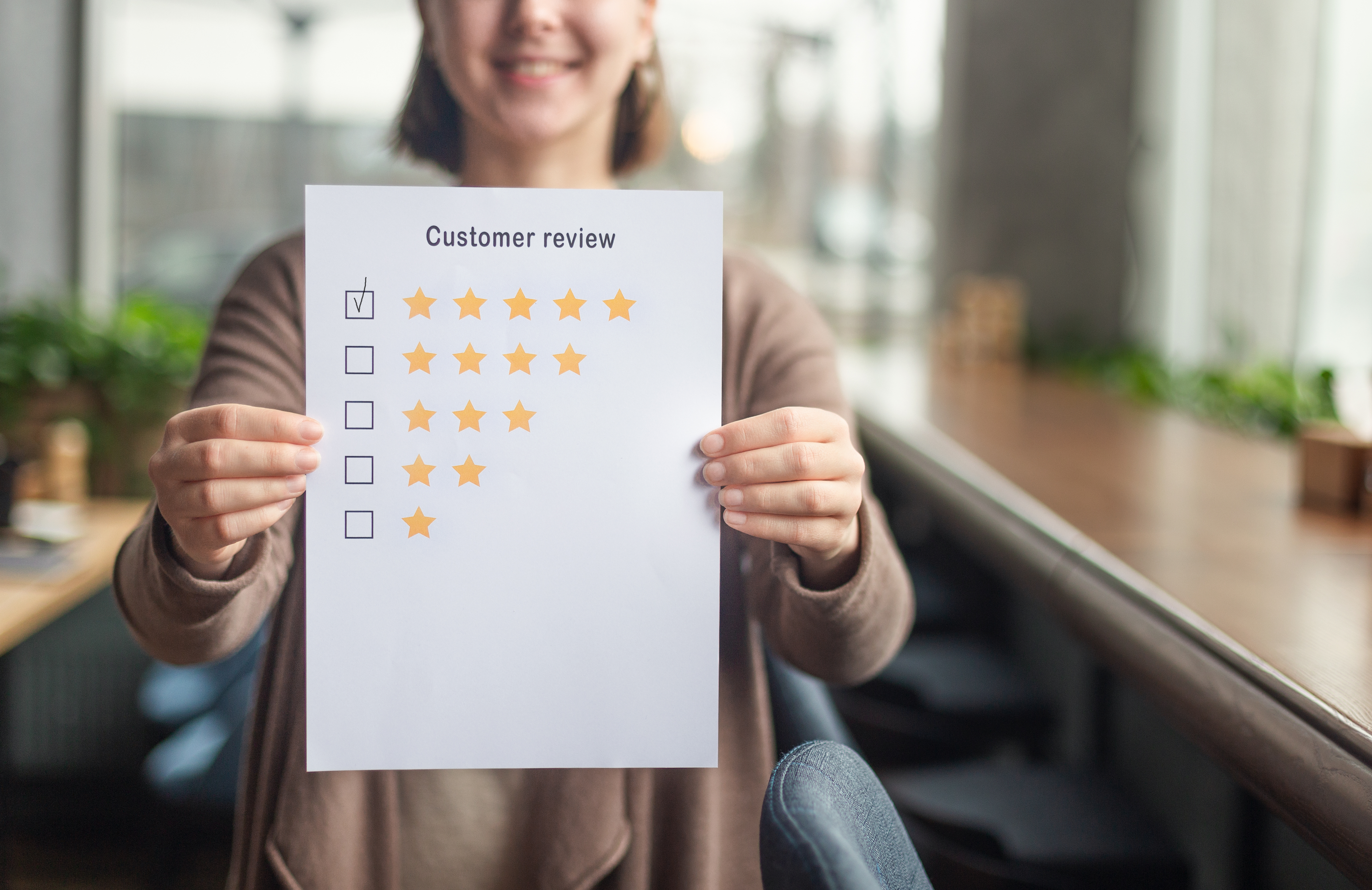 Unrecognizable woman showing five stars evaluating coworking place